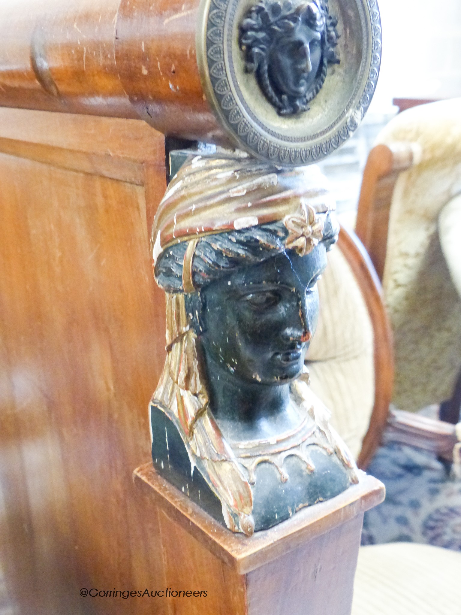 A 19th century French mahogany Egyptian taste three piece bedroom suite, comprising a three quarter size bed, a marble topped three dra